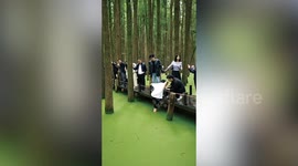 Man retrieves phone from algae-covered lake using his toes