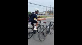 Cyclist rides road bike while pushing second bicycle