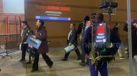 Men with projectors strapped to their bodies advertise for Kamala Harris' presidential campaign