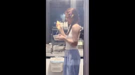 Student looks terrified of saucepan while trying to cook for the first time