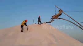 China: Workers Raking Salt in Guanxi Salt Farm in Lianyungang