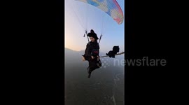 Chinese woman dressed as witch rides broom as she paraglides 1,000m in air