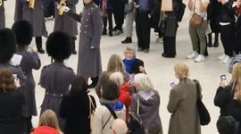 Woman grooves to Abba's 'Dancing Queen' performed by the Band of the Scots Guards on Poppy Day