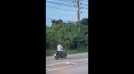 Motorcycle rider carries bottle of beer on his head