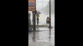 Kind onlooker runs into rain to help wheelchair user struggling through deluge