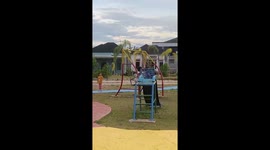 Children swing high on playground in Banjarmasin