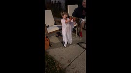 A Boy in a ghost costume hands out candy to no one on Halloween