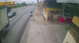 Food deliveryman squeezed by truck against parked car