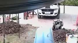 Toddlers topple over with toy truck trying to drive across garden hill