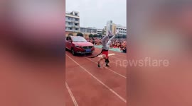 Chinese teacher pulls car while doing handstand
