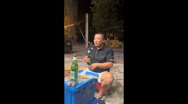 Man falls off chair while trying to drink beer in Sanya, Hainan
