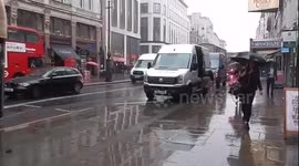 Londoners Trying To Avoid Getting Soaked By Cars Driveing Through Puddles