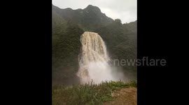 Torrent of water flows off mountainside like a waterfall