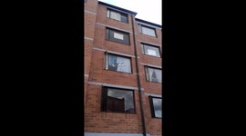 Cat resting on window in funny position in Bogota, Colombia