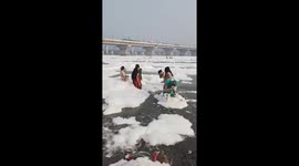 Locals bathe in polluted river... using toxic foam as shampoo