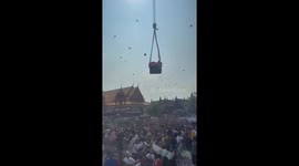 Businessman throws money from crane for locals