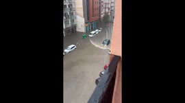 Car Drives Through Flooded Street in Spain