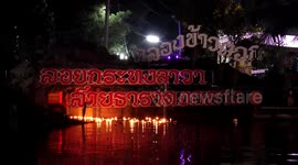 Worshippers release candle-lit floats into river for Buddhist festival