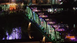 Thousands of people cross the Ping River iron bridge in Chiang Mai to celebrate the Festival of Lights