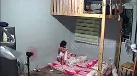 Caring toddler gently puts blanket on her sleeping sister