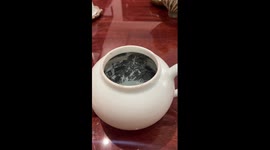 Chinese artisan paints intricate scene inside teapot