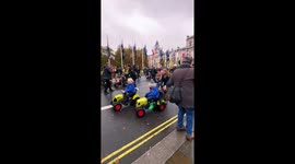 Children ride toy tractors during farmer protest in London