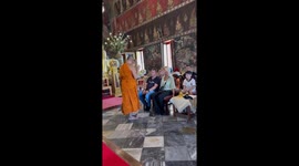 Buddhist monk amuses tourists by whacking them on the head with grass