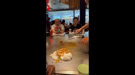 Skilled chef breaks egg on spatula and draws heart with the whites