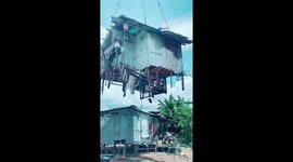 Family moves house by having their shack lifted with a crane