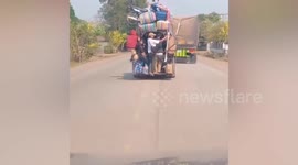 Locals stack motorcycle on top of suitcases while riding bus