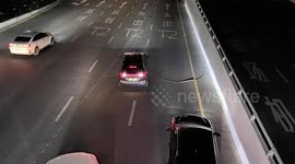 Cars drive over loose wire on motorway