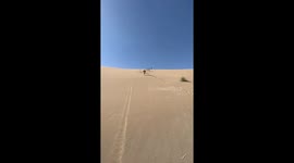 Person falls down sand dune in Varzaneh, Iran