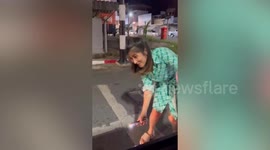 Driver stops her car to save stray cat stuck under wheels