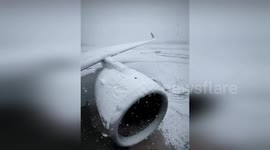 Plane covered in snow as flight from Paris is delyaed