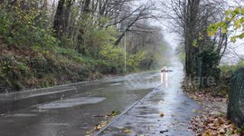 Vehicles driving through standing water on the road from Storm Bert