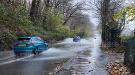 More Vehicles driving through standing water on the road from Storm Bert