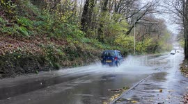 Different Vehicles driving through standing water on the road from Storm Bert