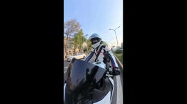 Female motorbike rider stops to rescue kitten