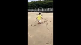 Boy falls into sand hole on beach