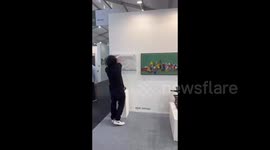 India: An indian artist supports Palestine by displaying a powerful banner and a watermelon, the symbol of Palestine, at the Art Mumbai gallary