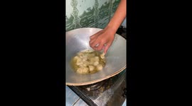 Fried fish ball get stuck on boy's finger when he tries to cook