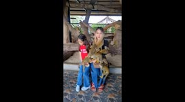 Unruly squirrel monkeys climb all over mum and daughter at zoo