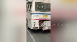 Passengers cram into the trunk of bus in India