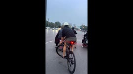 Chinese cyclist balances effortlessly at intersection