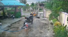 Kid inserts hose into motorcycle exhaust in Chiang Rai, Thailand