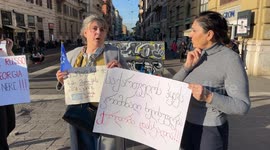 Women of Georgian origin hold signs protesting the results of the Georgian elections in an impromptu sit-in in Rome.