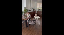 Baby can't take eyes off her sister eating lunch in Chelyabinsk, Russia