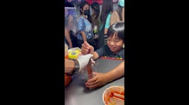 Youngster bites off head of live squid at food stall