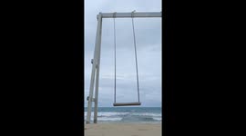 Beachgoer's video goes wrong when she topples backwards from swing