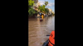 Housewife defies floods by cycling to shops through waist-deep water
